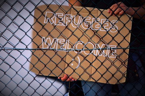 "Refugees Welcome" Schild hinter Zaun