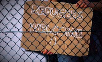 "Refugees Welcome" Schild hinter Zaun